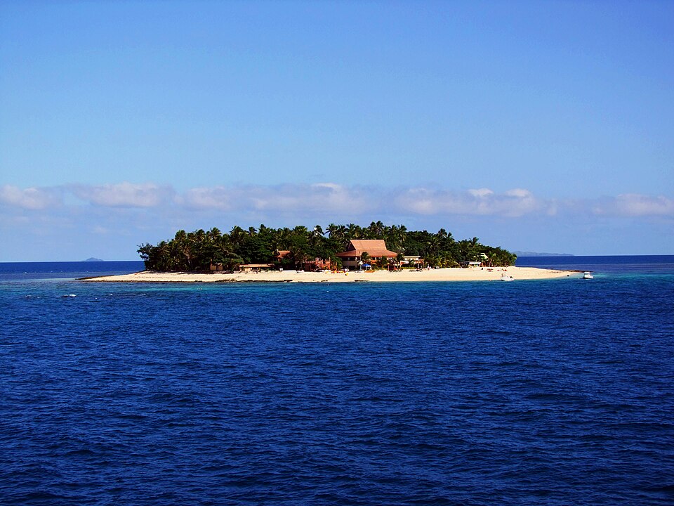 Una islita con palmeras rodeada de mar azul en las Mamanuca