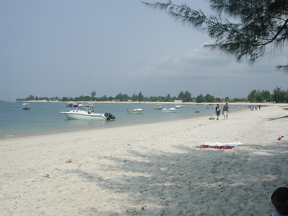 Playa de arena blanca con lanchas en el agua en Pointe Denis