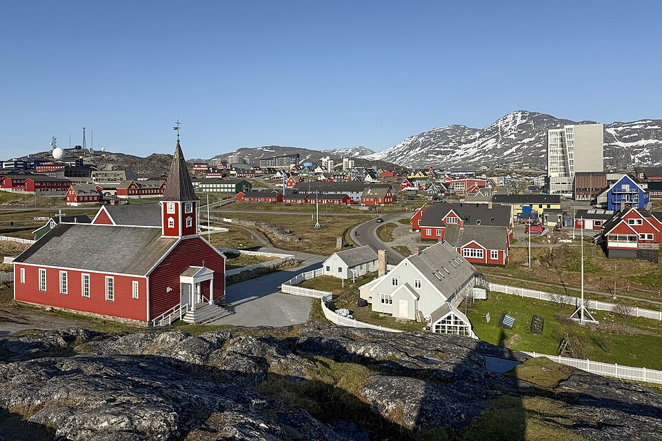 Edificios de colores de Nuuk frente al mar con montañas detrás