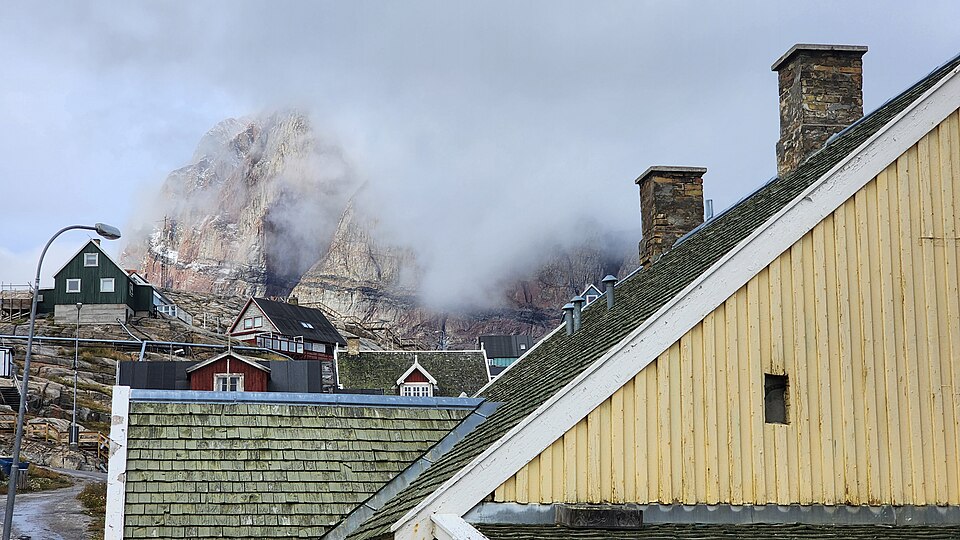 Casas de colores de Uummannaq al pie de su montaña rojiza entre la niebla