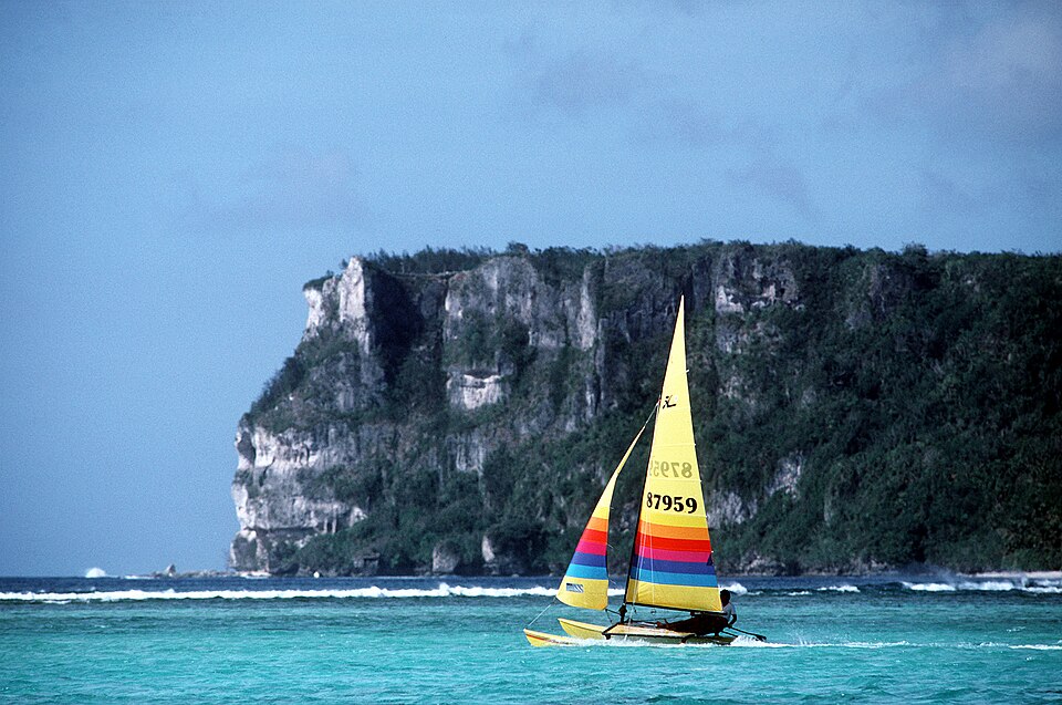 Un velero de colores frente al acantilado de la Punta de los Dos Amantes