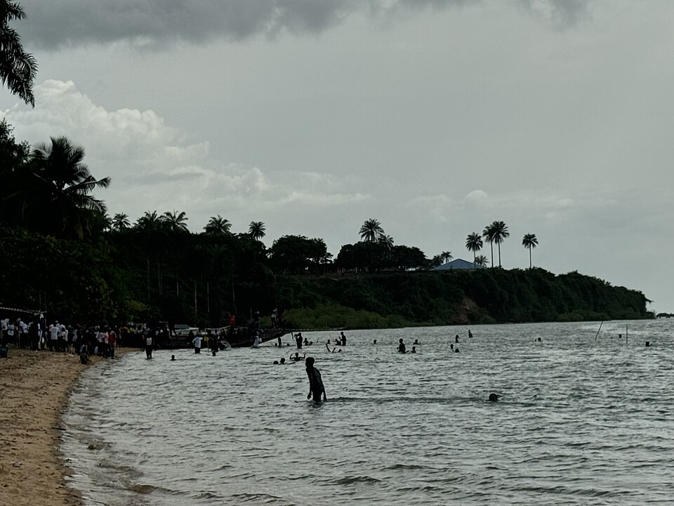 Gente bañándose en una playa de Bubaque rodeada de palmeras