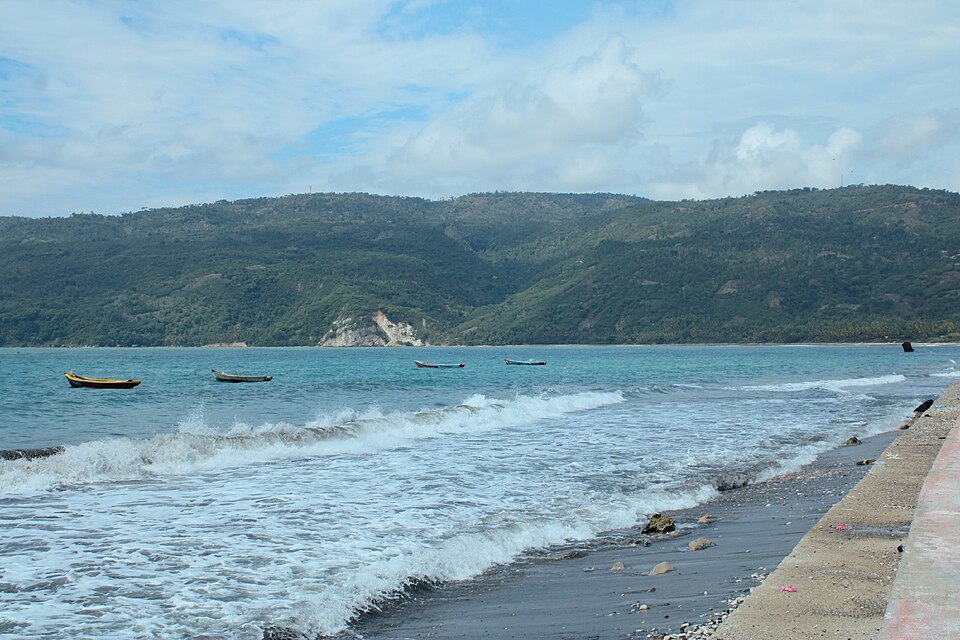 La bahía de Jacmel con olas y montañas verdes al fondo