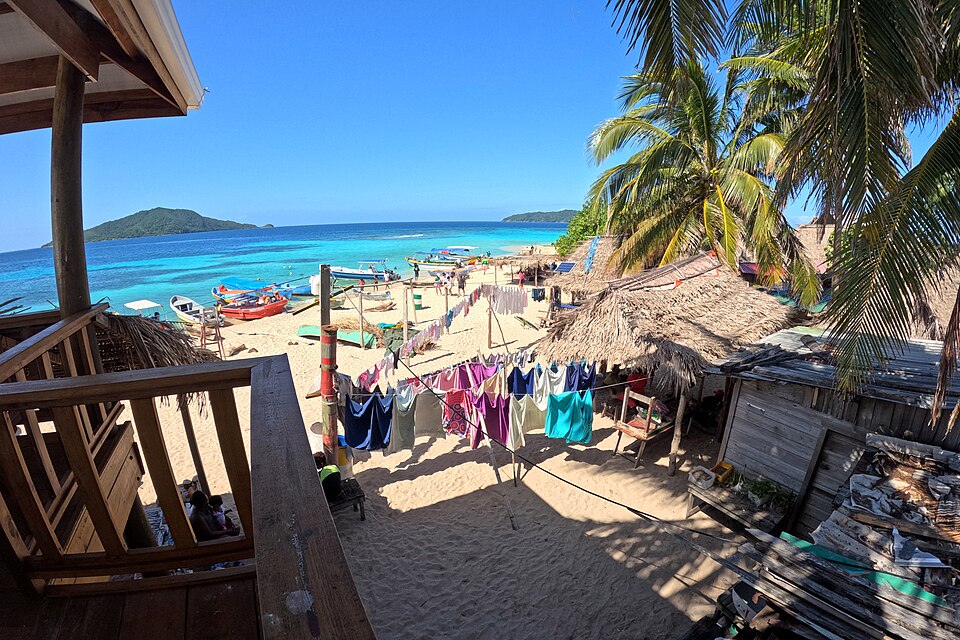 Cabañas de una aldea garífuna en la playa de Cayos Cochinos, frente al agua turquesa