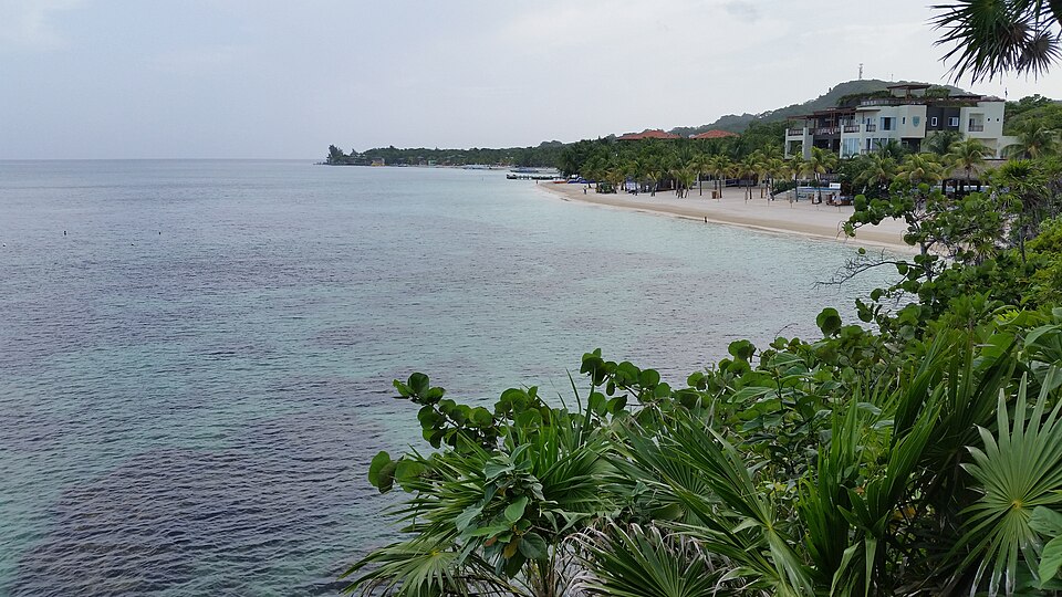 La costa de West Bay en Roatán con agua clara y vegetación tropical