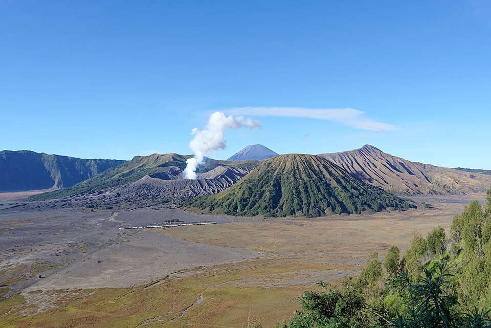 El volcán Bromo humeante en la caldera de Tengger con el Semeru al fondo