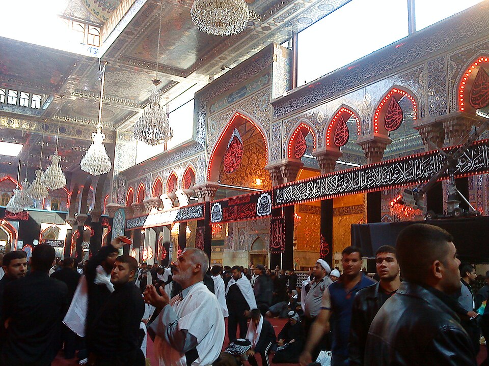 Peregrinos en el interior decorado con espejos del santuario del imán Husayn