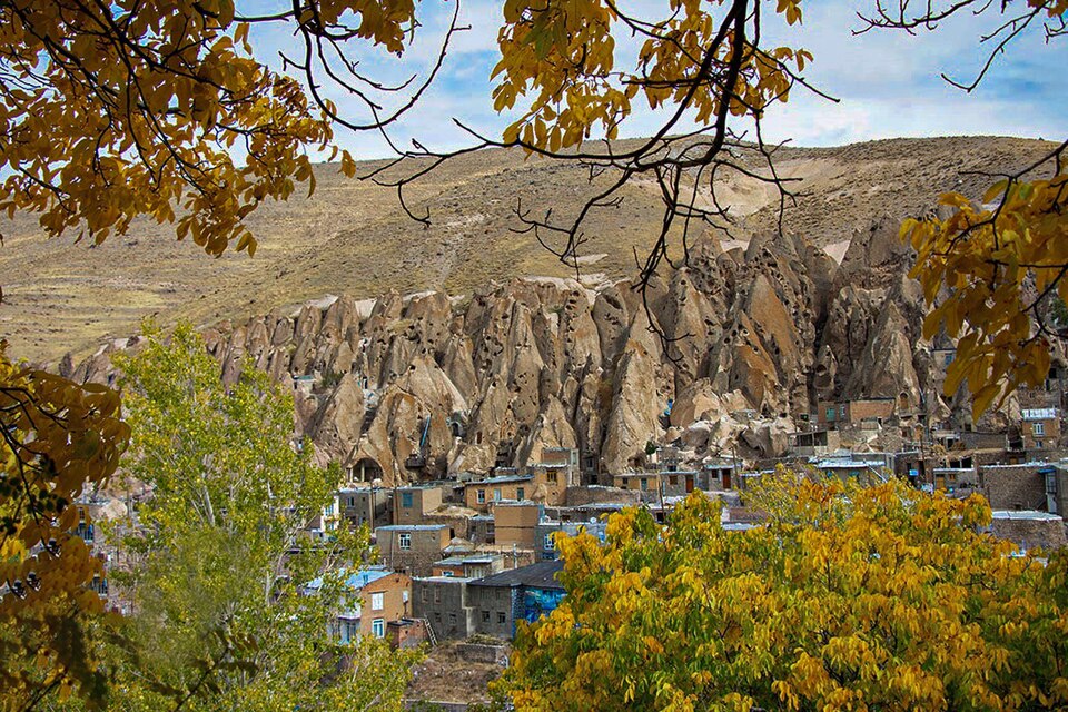 Las casas en conos de roca de Kandovan entre árboles de otoño