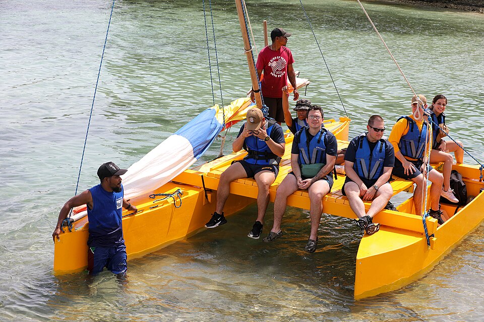 Una canoa tradicional marshalesa con balancín y vela en el agua