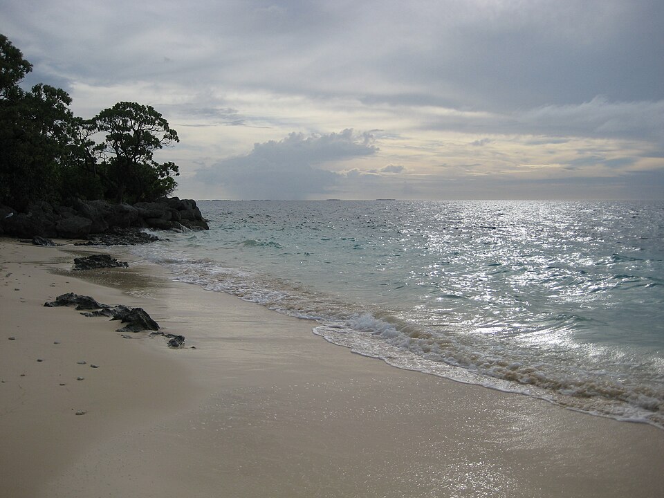 Una playa de la laguna de Kwajalein con el sol reflejado en el agua