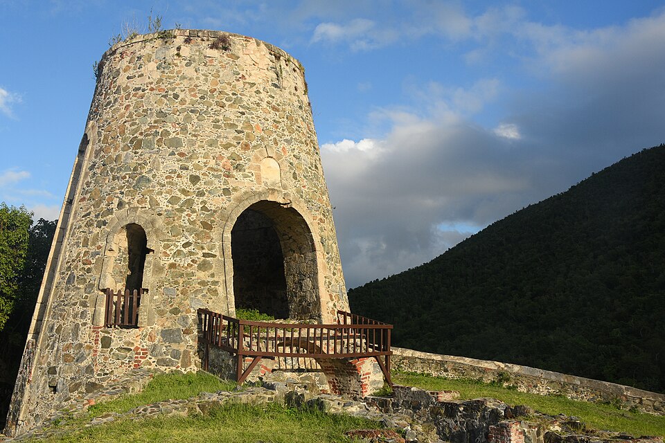El molino de piedra en ruinas de la hacienda Annaberg con montañas verdes al fondo