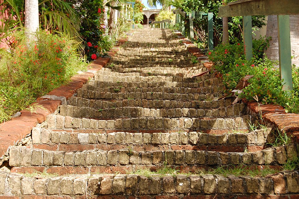 La escalinata de ladrillo de los 99 escalones entre plantas con flores