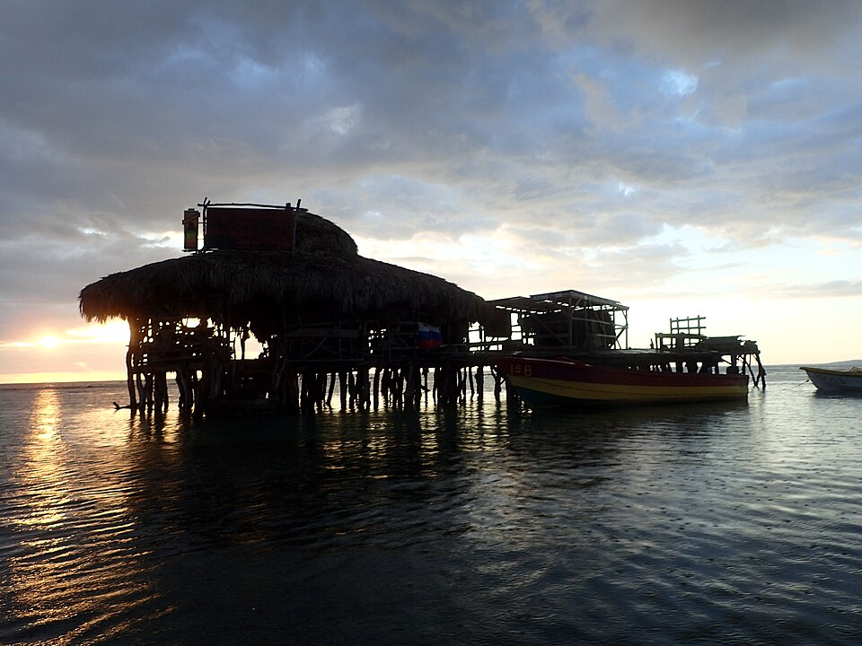 El bar de madera Pelican Bar sobre pilotes en el mar al atardecer