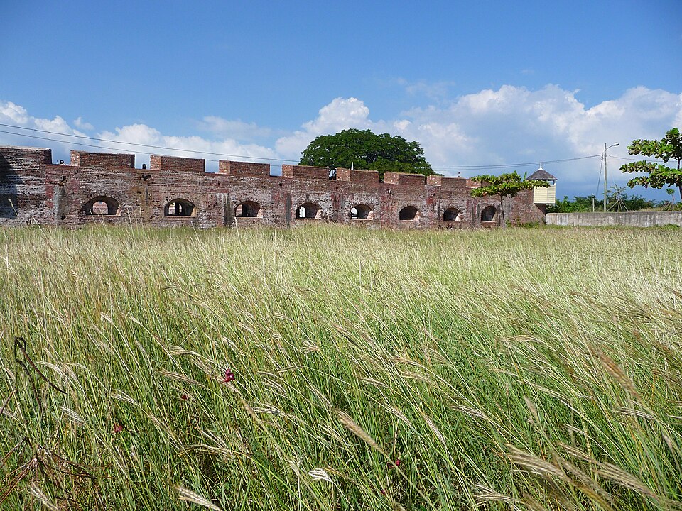 Los muros de ladrillo del fuerte Charles en Port Royal tras un campo de pasto