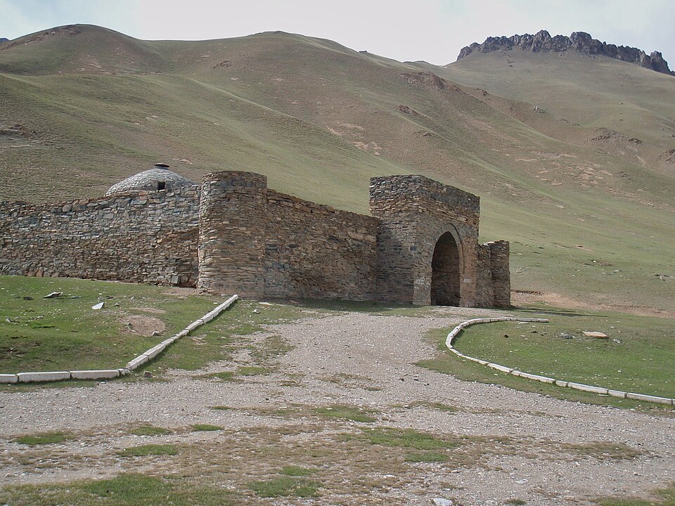 El caravasar de piedra de Tash Rabat en un valle verde