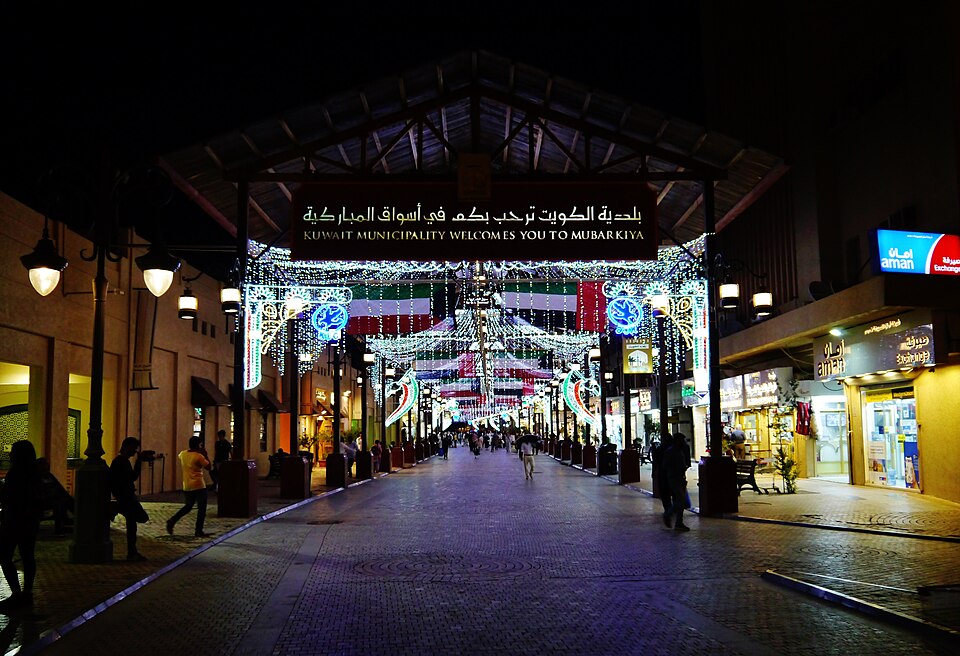 La entrada iluminada del zoco Al-Mubarakiya de noche
