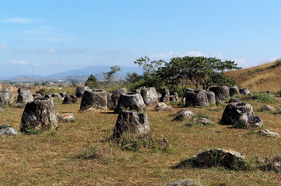 Jarrones de piedra antiguos dispersos en una pradera