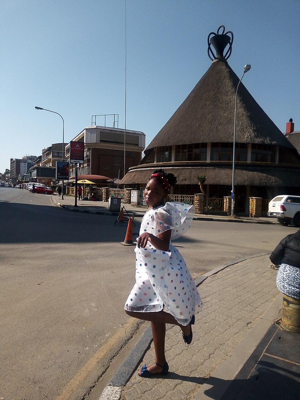 Edificio con techo de paja en forma de sombrero basoto en una calle de Maseru