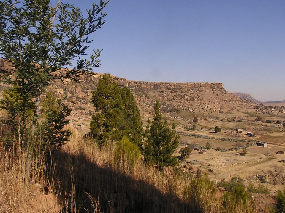 Meseta de Thaba Bosiu vista desde sus laderas, con árboles y pastizales secos