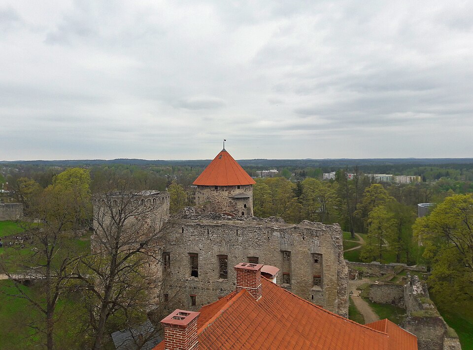 Las ruinas del castillo de Cēsis con su torre de techo rojo