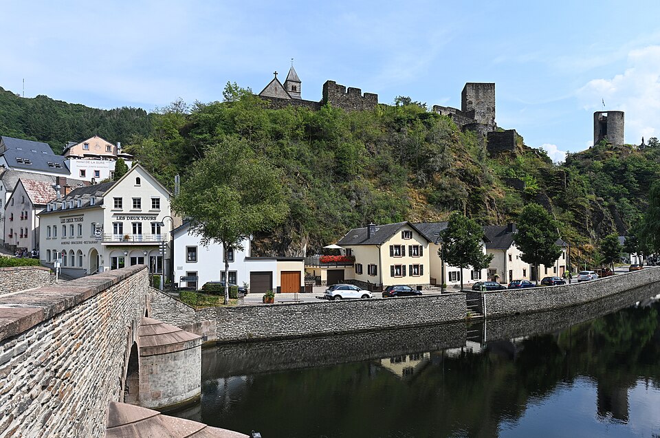 Esch-sur-Sûre junto al río con las ruinas del castillo en la colina