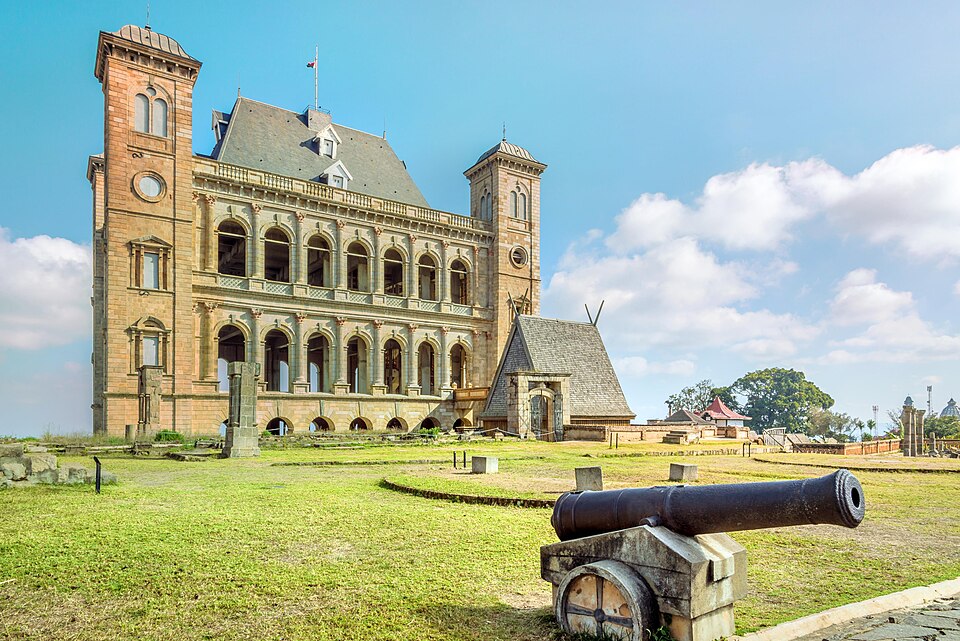Palacio de piedra con torres del Rova de Antananarivo y un cañón antiguo en el jardín