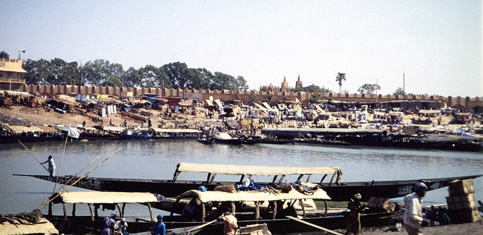 Pinazas de madera amarradas en el puerto de Mopti, con la ciudad al fondo