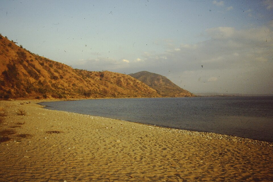 Playa de arena de Chiuanga a orillas del lago Niassa con cerros al fondo