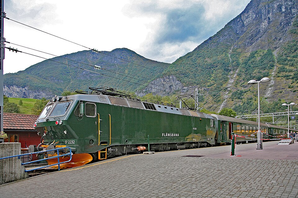 Tren verde de Flåmsbana en la estación de Flåm, entre montañas
