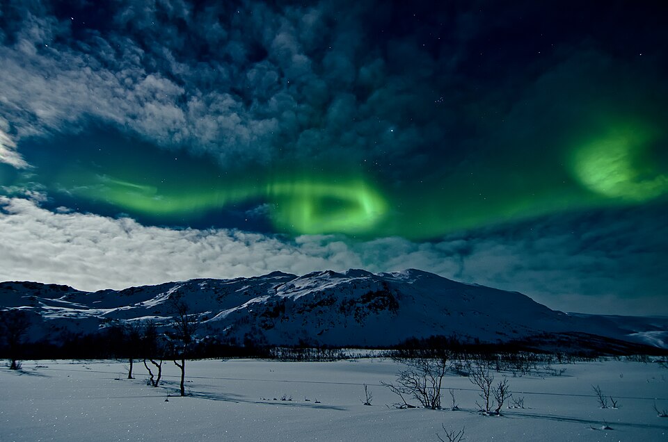 Aurora boreal verde sobre las montañas nevadas de Tromsø