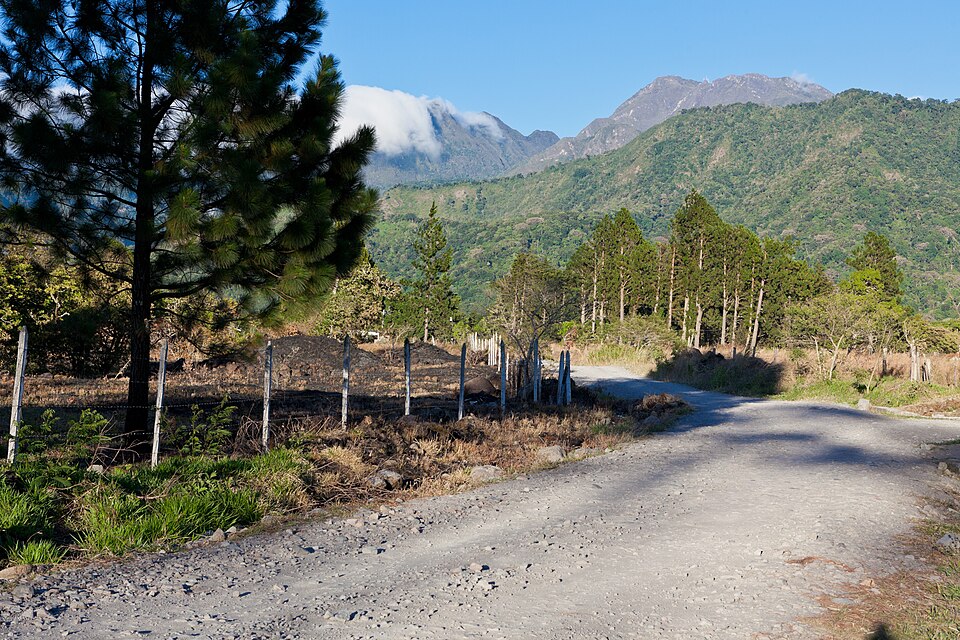 La cumbre del volcán Barú entre nubes vista desde un camino con pinos