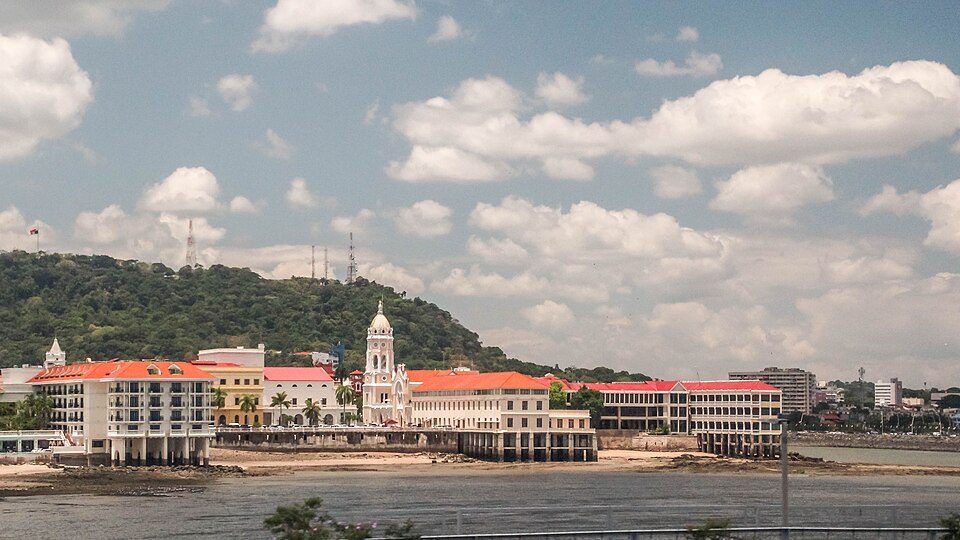 Edificios coloniales del Casco Viejo frente al mar con cerros verdes detrás