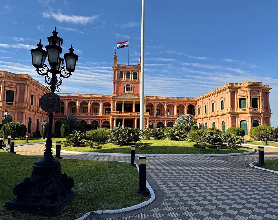 El Palacio de los López en Asunción, de color salmón, con jardines y un farol