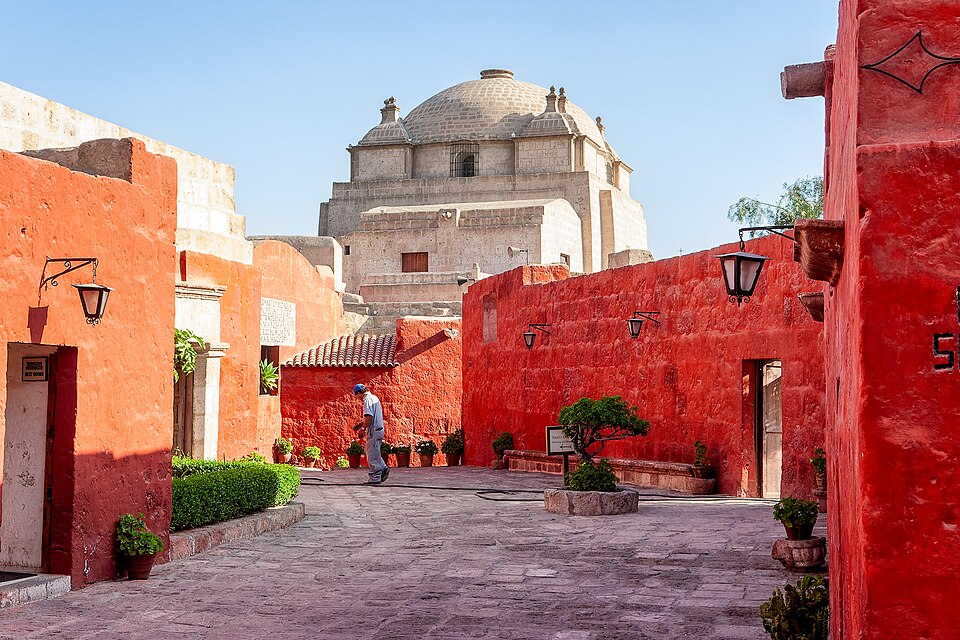 Un patio del monasterio de Santa Catalina con muros rojos y una cúpula blanca