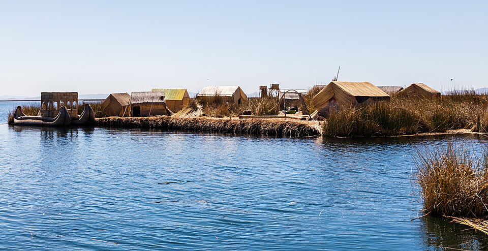 Una isla flotante de totora con casas de juncos en el lago Titicaca