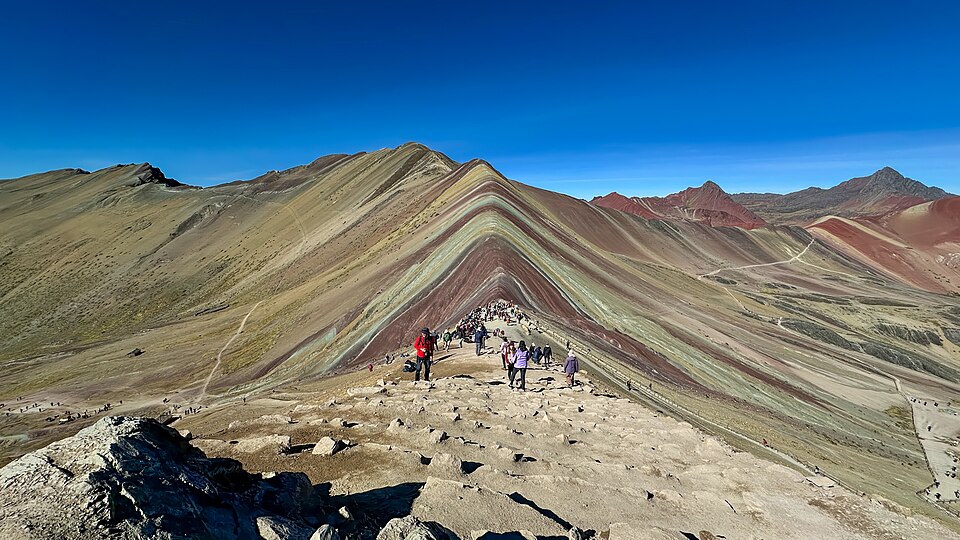 La montaña Vinicunca con franjas de colores bajo un cielo azul intenso