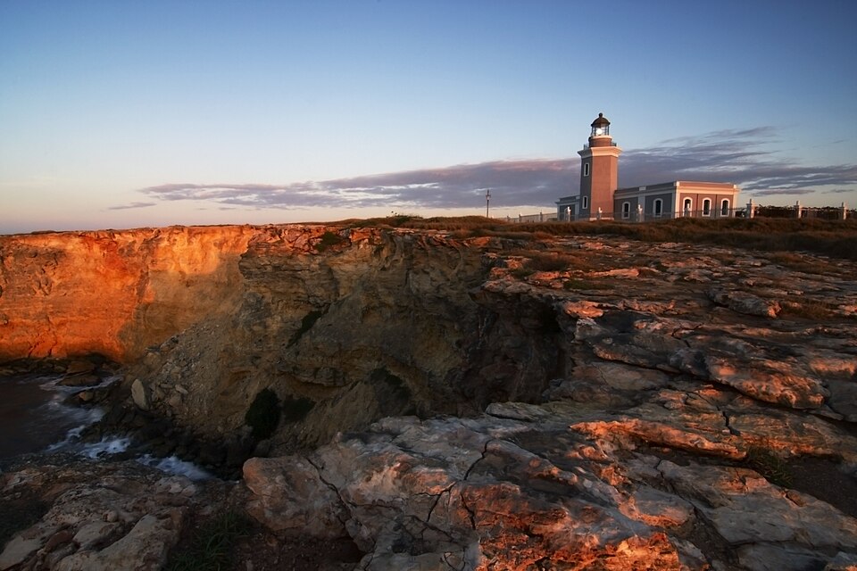 El faro de Los Morrillos sobre acantilados rojizos al atardecer