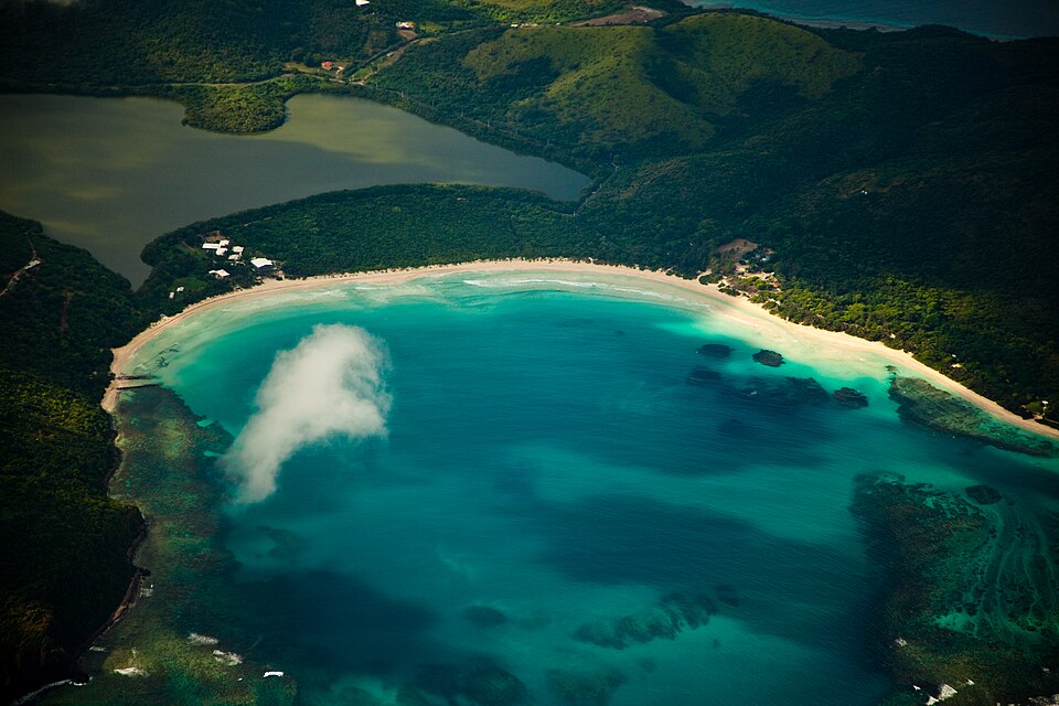 Vista aérea de la playa Flamenco con arena blanca y agua turquesa en forma de herradura