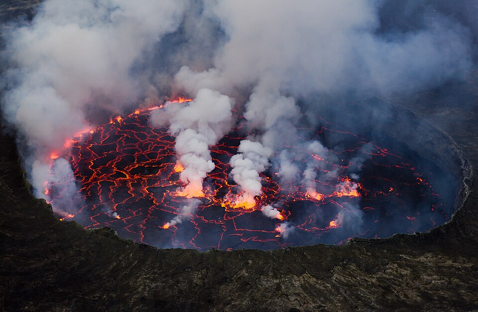 Lago de lava incandescente dentro del cráter del Nyiragongo entre humo