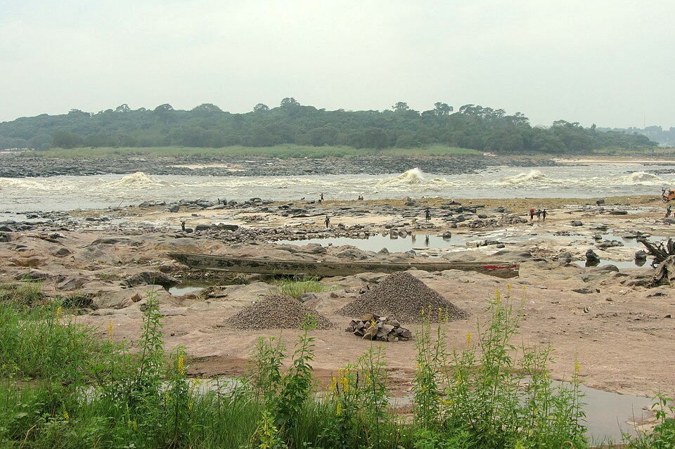 Orilla rocosa del río Congo en Kinsasa con rápidos y bosque al fondo