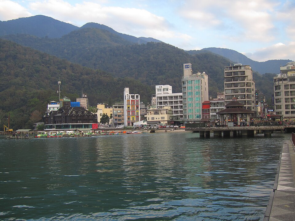 El Lago del Sol y la Luna con el muelle y montañas verdes detrás