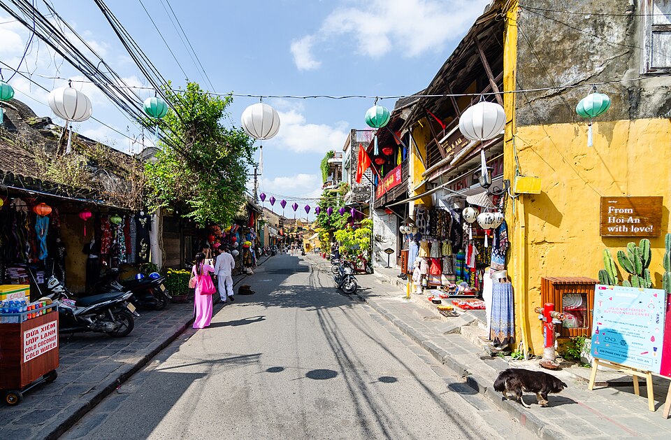 Una calle de Hoi An con casas amarillas y linternas colgadas