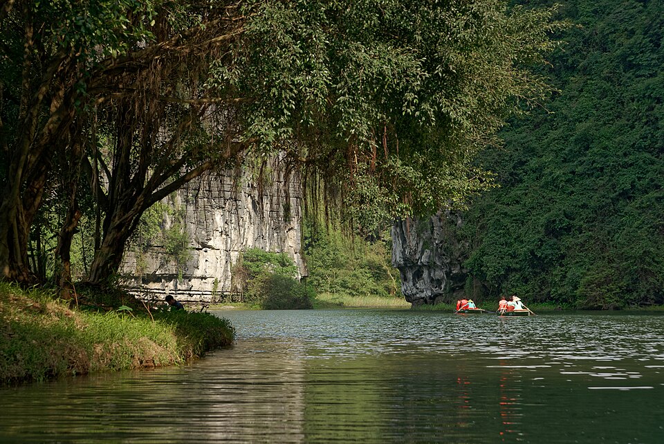 Un bote de remos en un río entre montañas de caliza en Trang An